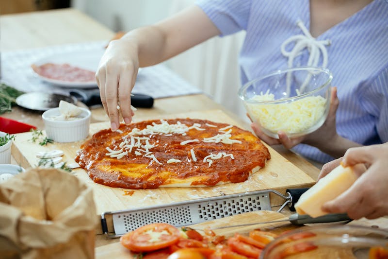 Pizza being made by hand with fresh toppings
